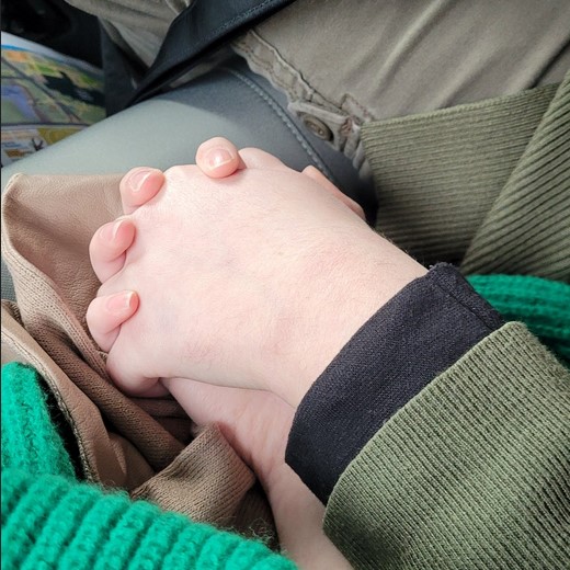 Two hands are pictured being held close to one another